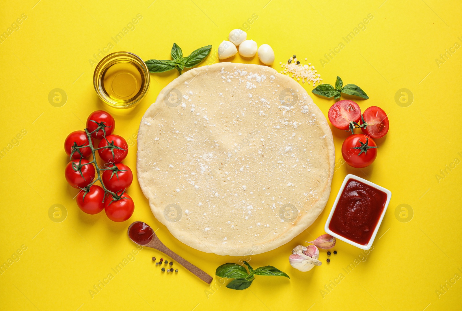 Photo of Flat lay composition with pizza crust and fresh ingredients on yellow background