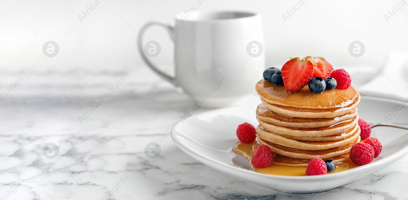 Image of Tasty pancakes with berries and honey on plate, space for text. Banner design