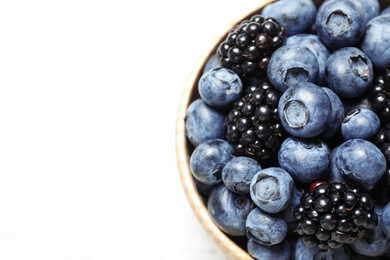 Photo of Blueberries and blackberries in bowl on white background, closeup