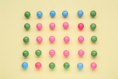 Photo of Many bright chewy gumballs on beige background, flat lay