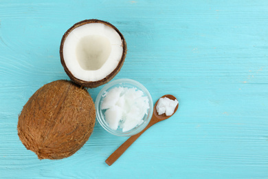 Flat lay composition with organic coconut oil on light blue wooden table. Healthy cooking