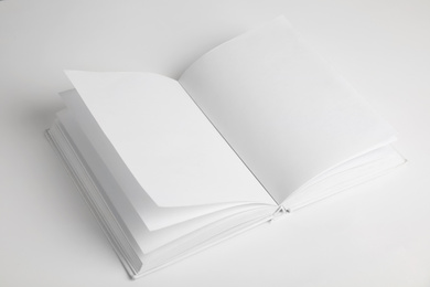 Photo of Open book with blank pages on white background