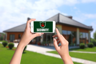 Image of Alarm system. Woman using phone outdoors, closeup