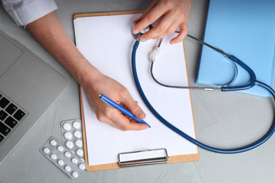 Photo of Doctor working at desk in office, top view. Medical service