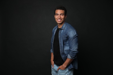 Photo of Handsome young African-American man on black background