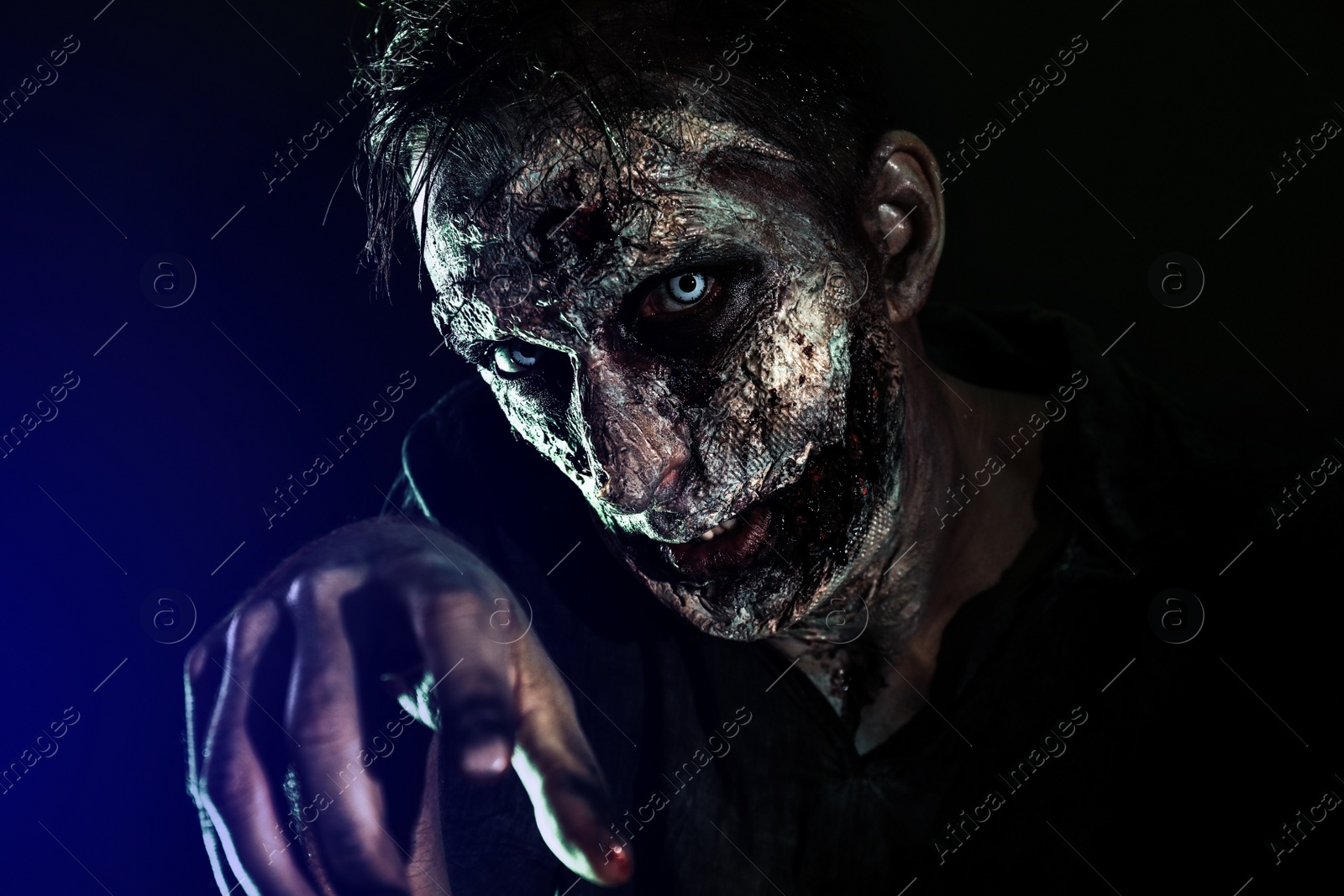 Photo of Scary zombie on dark background. Halloween monster