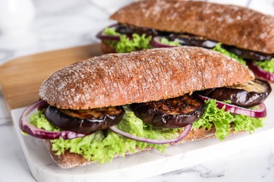 Delicious fresh eggplant sandwiches served on white table, closeup