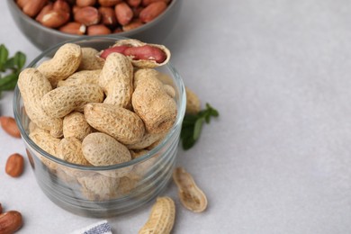 Photo of Fresh unpeeled peanuts on grey table, closeup. Space for text