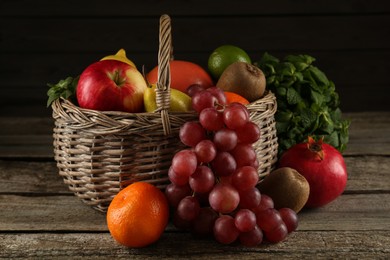 Photo of Fresh ripe fruits and wicker basket on wooden table