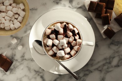 Photo of Cup of aromatic hot chocolate with marshmallows served on light marble table, flat lay