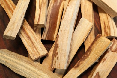 Photo of Many palo santo sticks on wooden table, flat lay