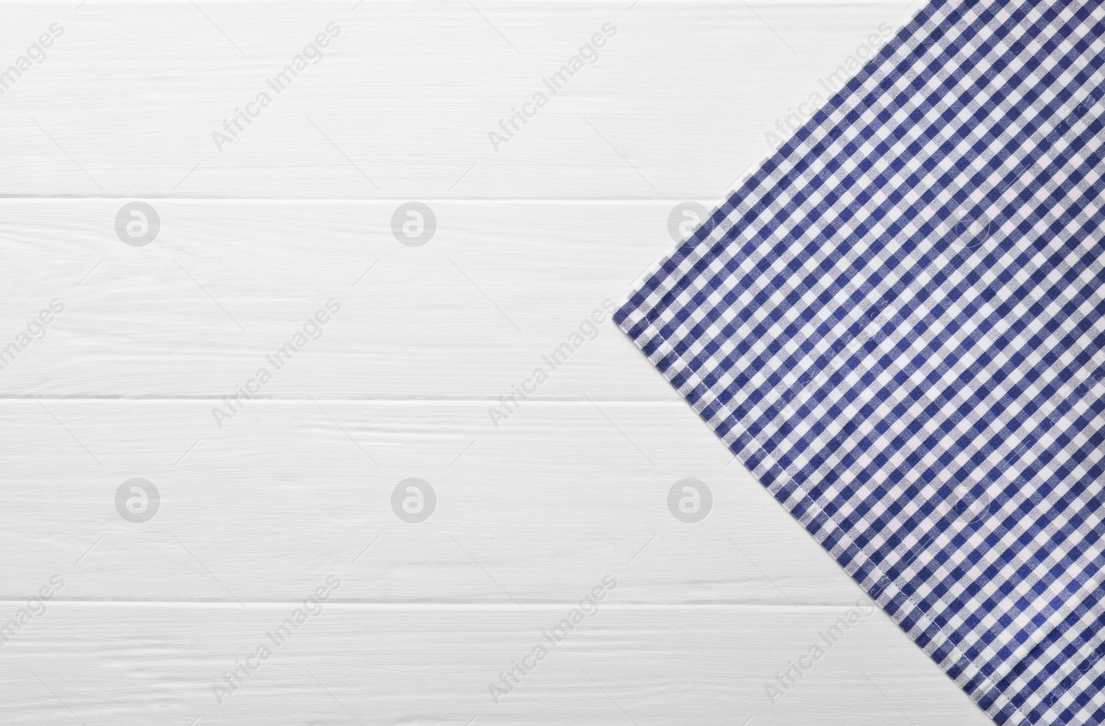 Photo of Blue checkered tablecloth on wooden table, top view. Space for text