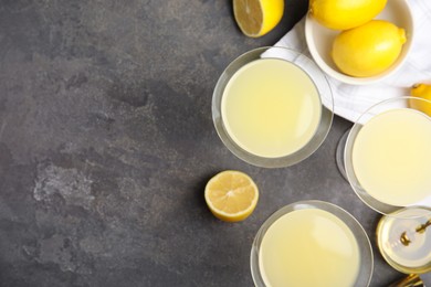 Photo of Delicious bee's knees cocktails and ingredients on grey table, flat lay. Space for text