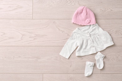 Photo of Set of baby clothes and accessories on wooden background, flat lay
