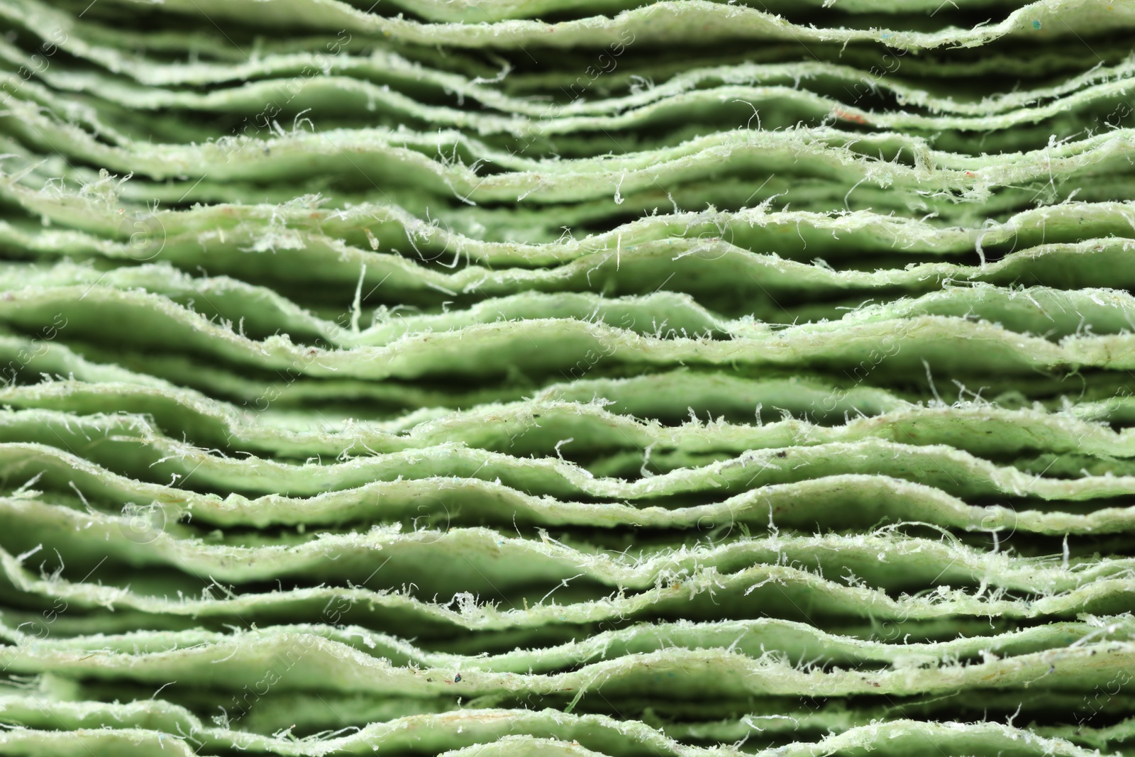 Photo of Texture of stacked light green paper napkins as background, macro view