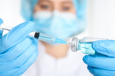 Photo of Doctor filling syringe with medication, closeup. Vaccination and immunization