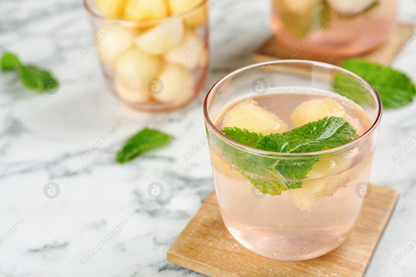 Photo of Glass with tasty melon ball drink on table