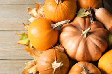 Photo of Ripe pumpkins on wooden background, flat lay. Holiday decoration