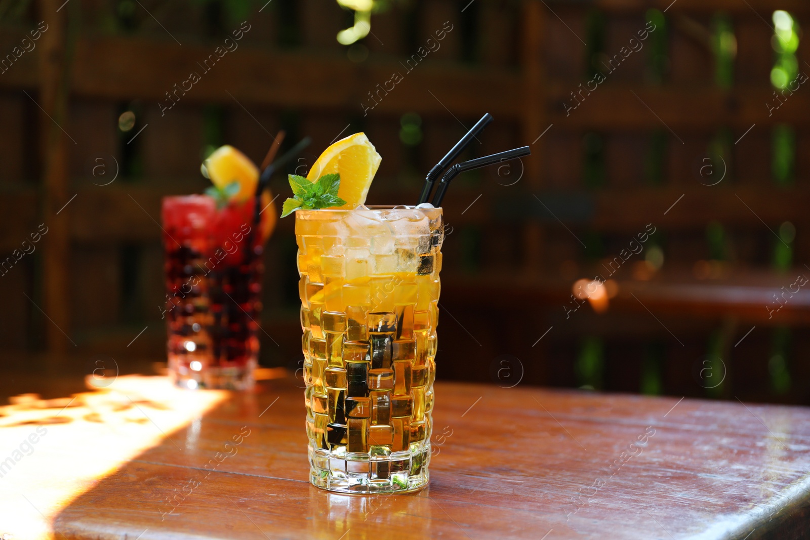 Photo of Glasses of delicious cocktails with ice on table