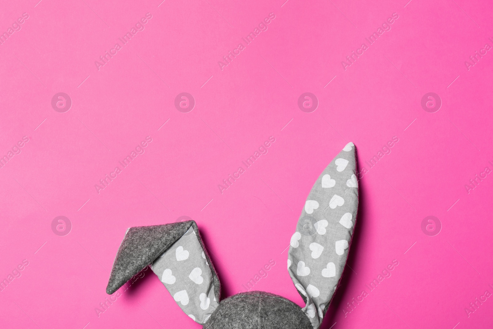 Photo of Funny Easter bunny ears on color background, top view with space for text