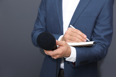 Photo of Professional journalist taking notes on dark background, closeup