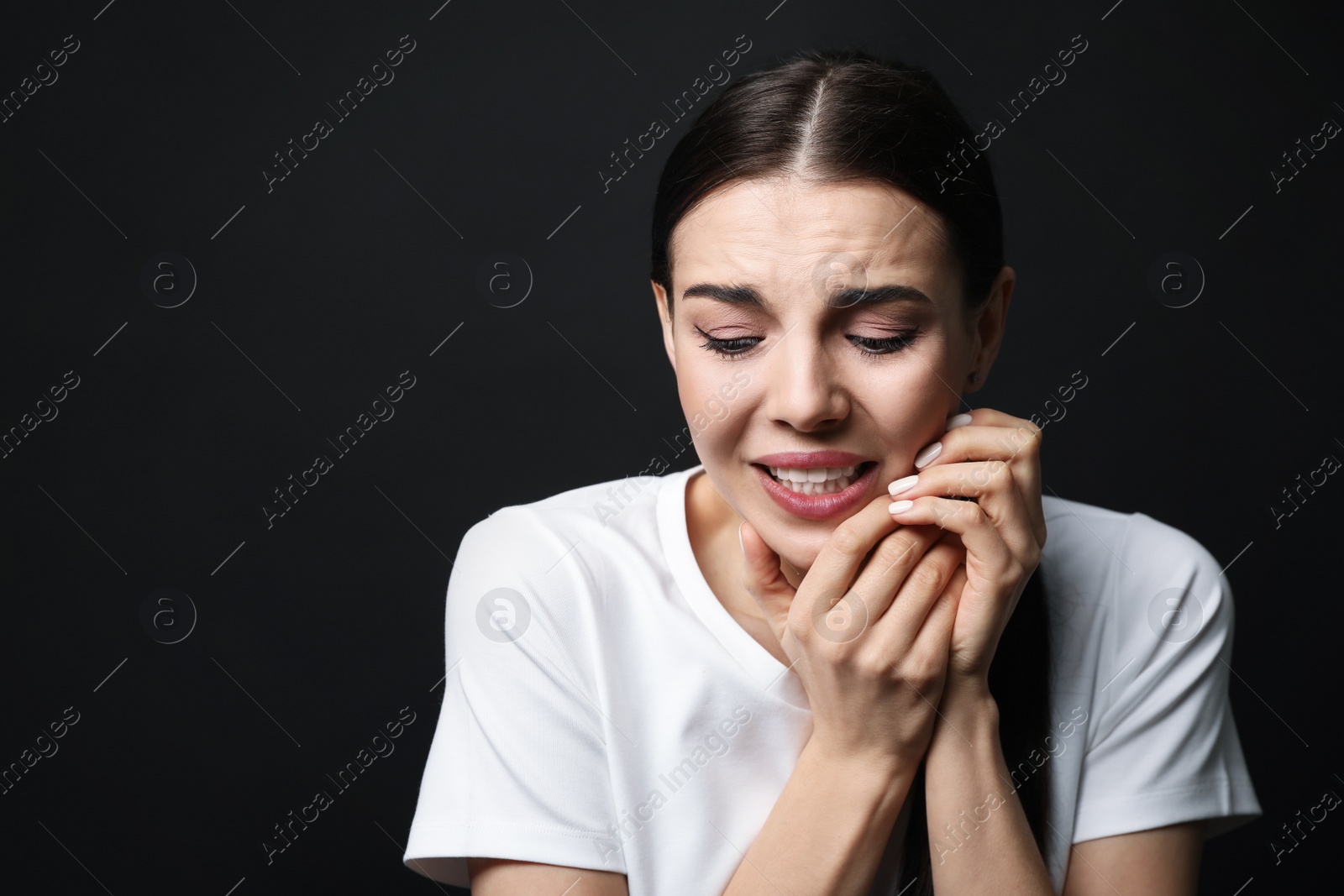 Photo of Young woman feeling fear on black background