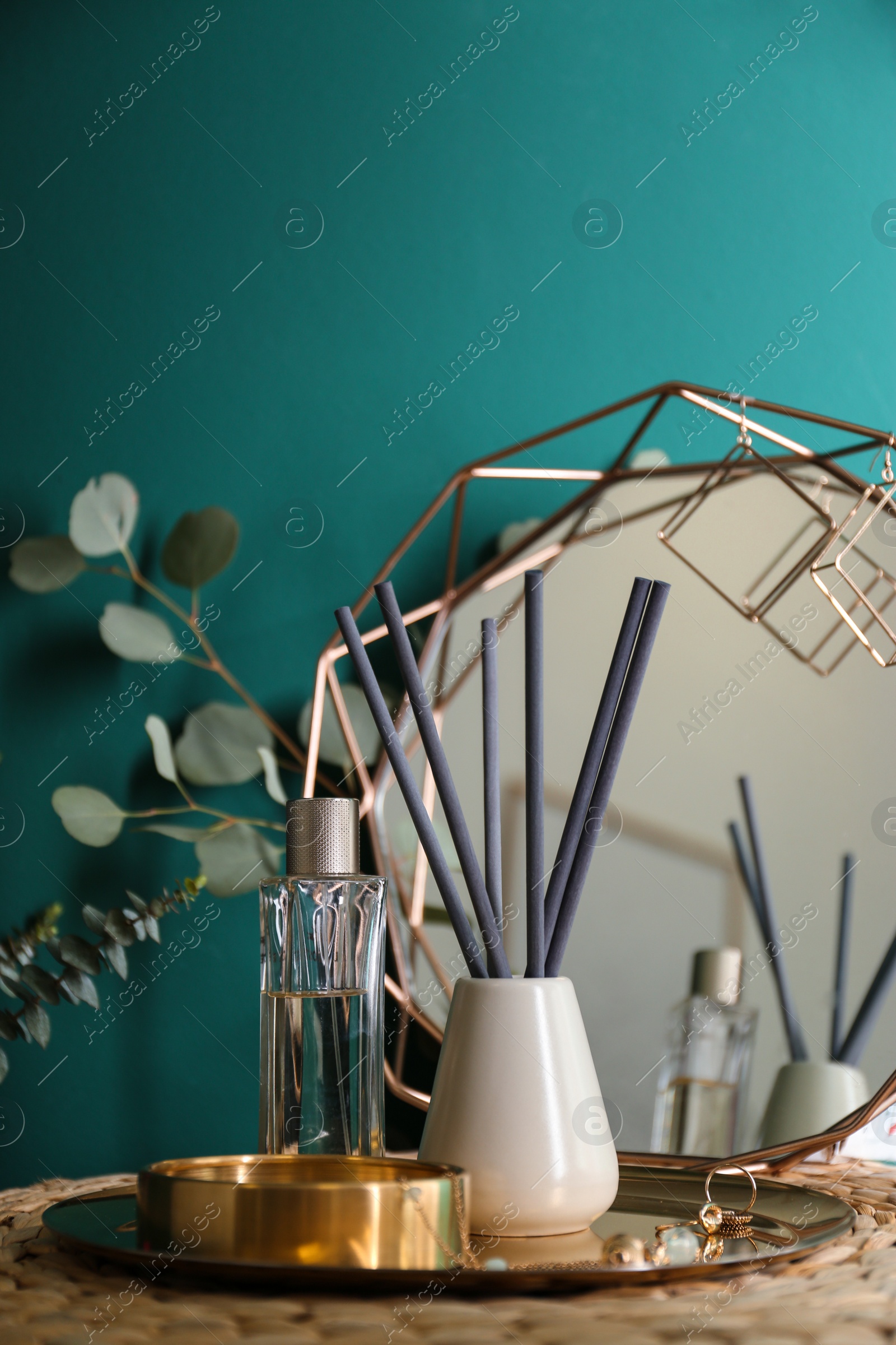 Photo of Composition with stylish accessories and interior elements on table near turquoise wall