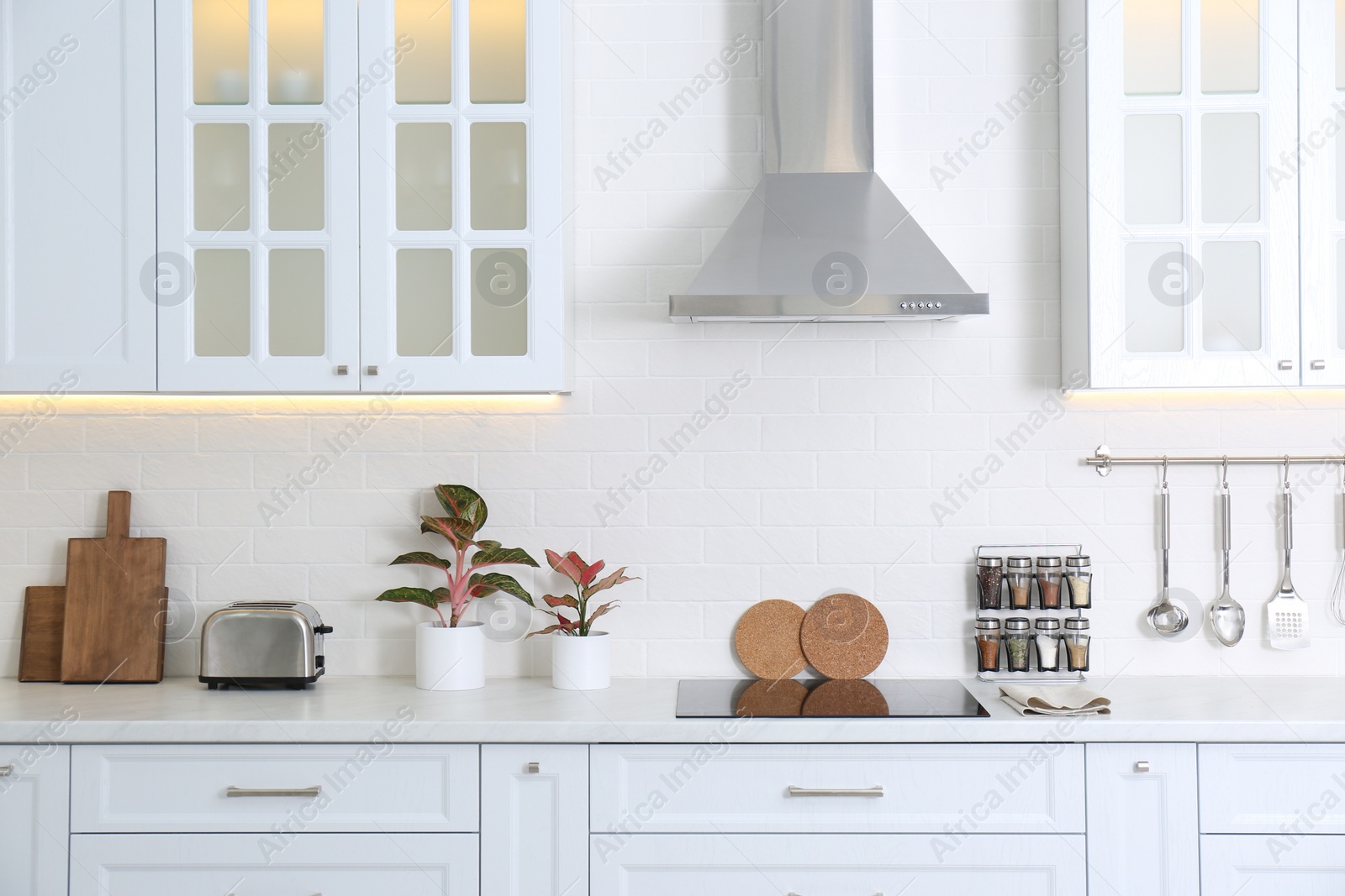 Photo of Modern toaster and household appliances on counter in kitchen