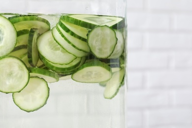Photo of Large jar of fresh cucumber water, closeup. Space for text