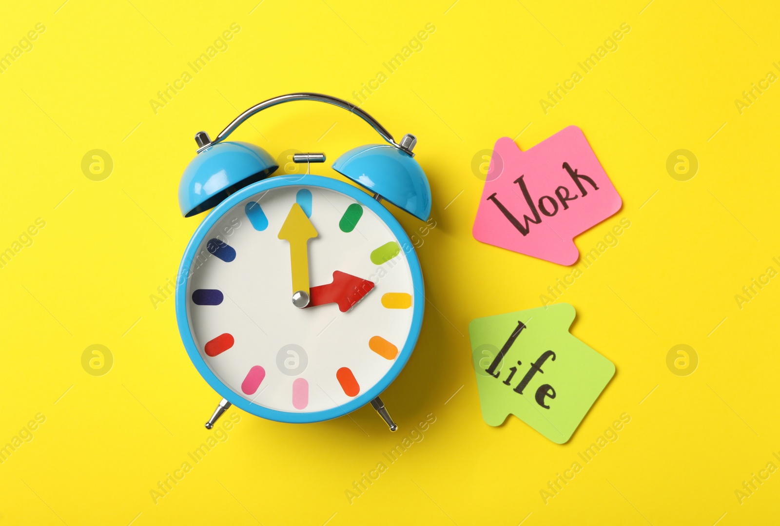 Photo of Alarm clock and sticky notes on yellow background, flat lay. Life work balance concept