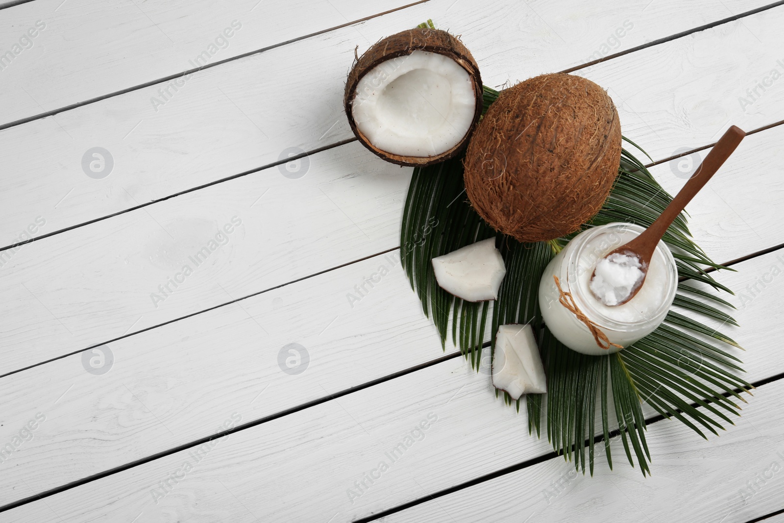 Photo of Flat lay composition with coconut oil on white wooden table, space for text. Cooking ingredients