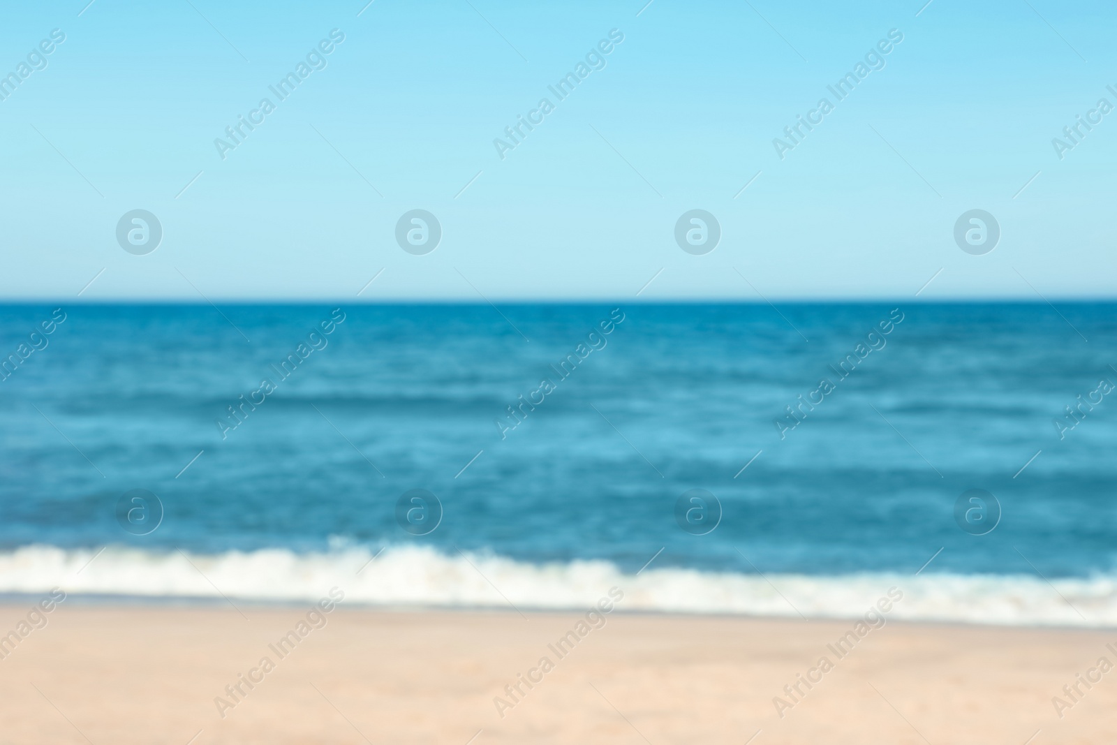 Photo of Blurred view of beautiful sea and sandy beach on sunny day