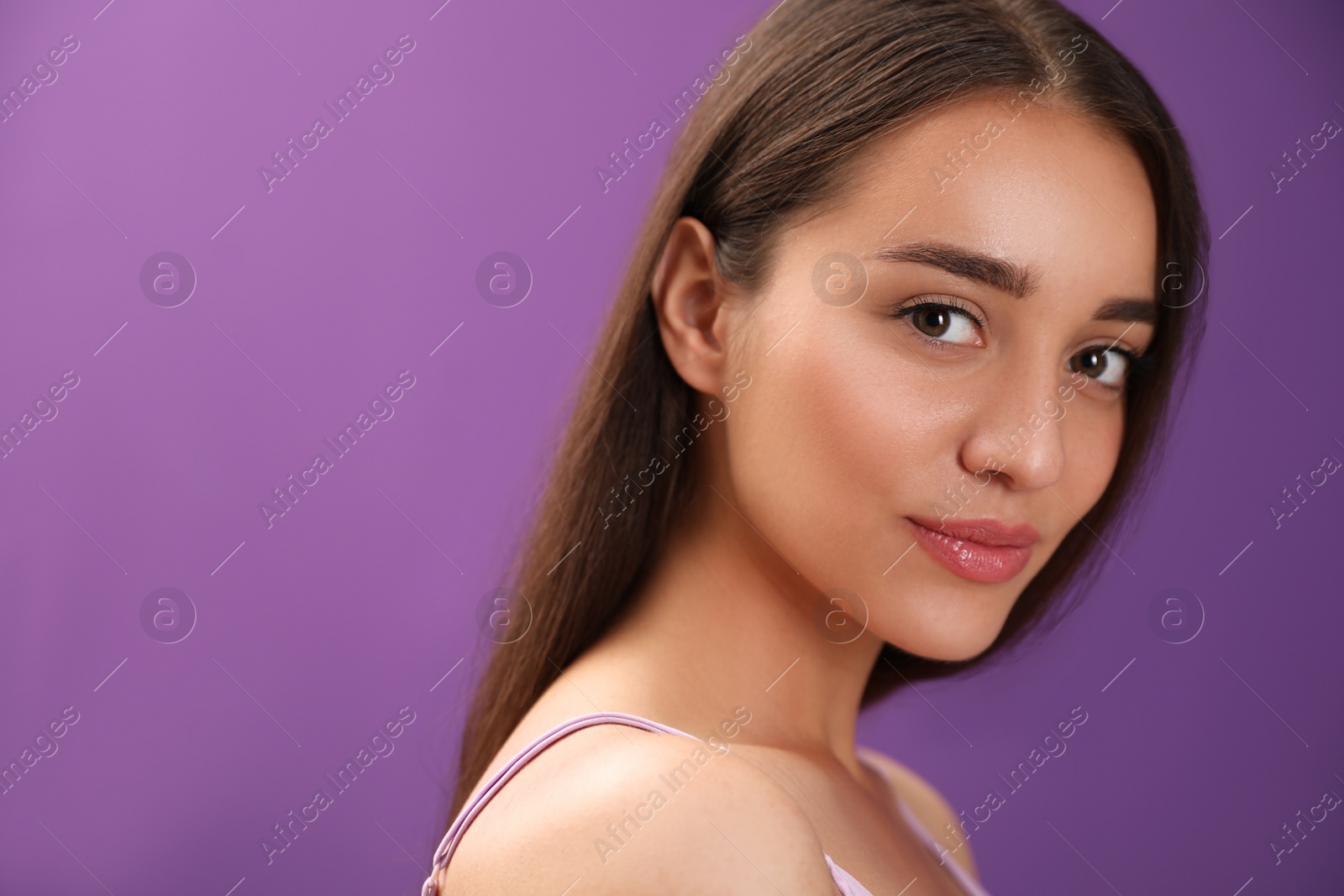 Photo of Portrait of beautiful young woman on purple background