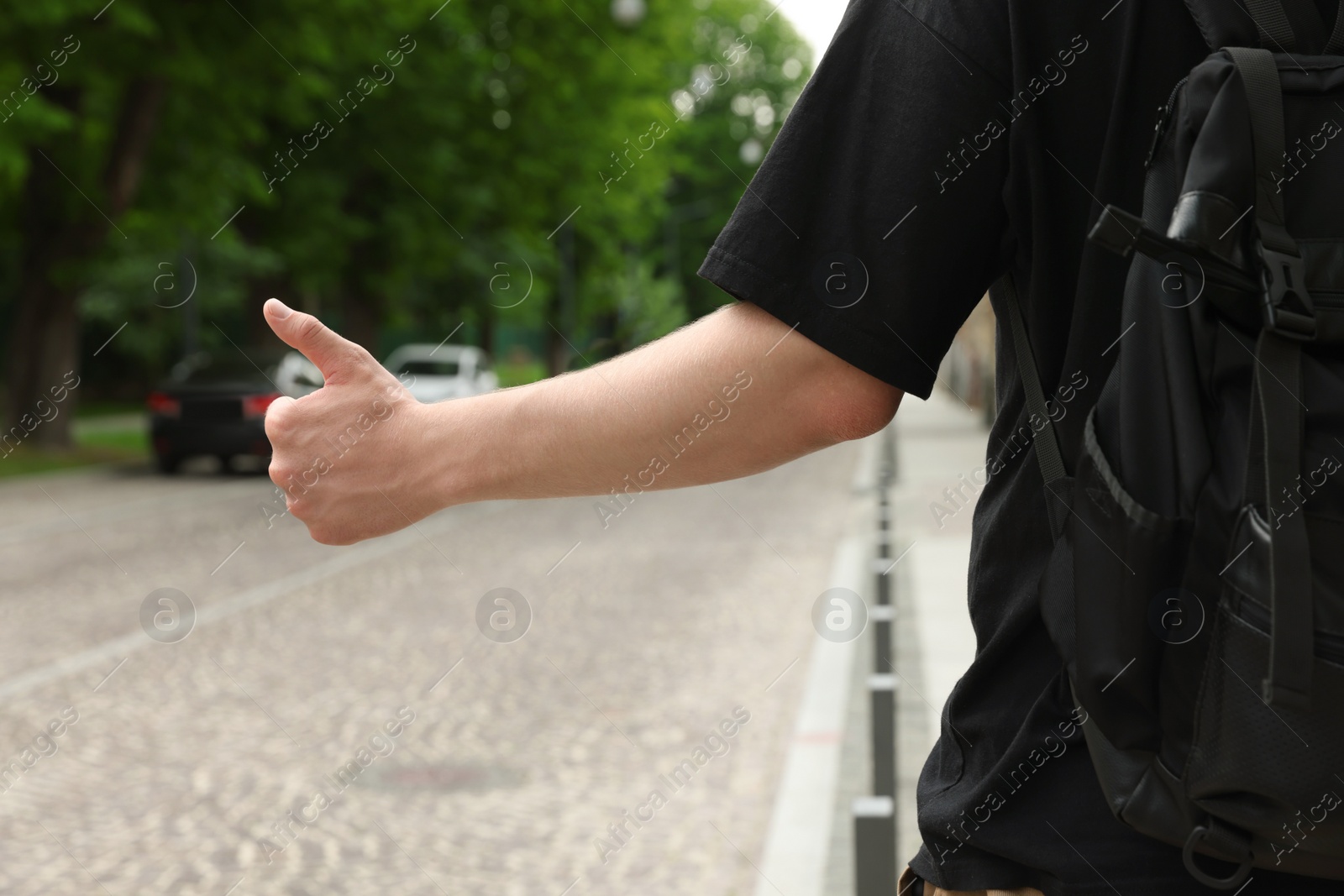 Photo of Man catching car on road, closeup. Hitchhiking trip