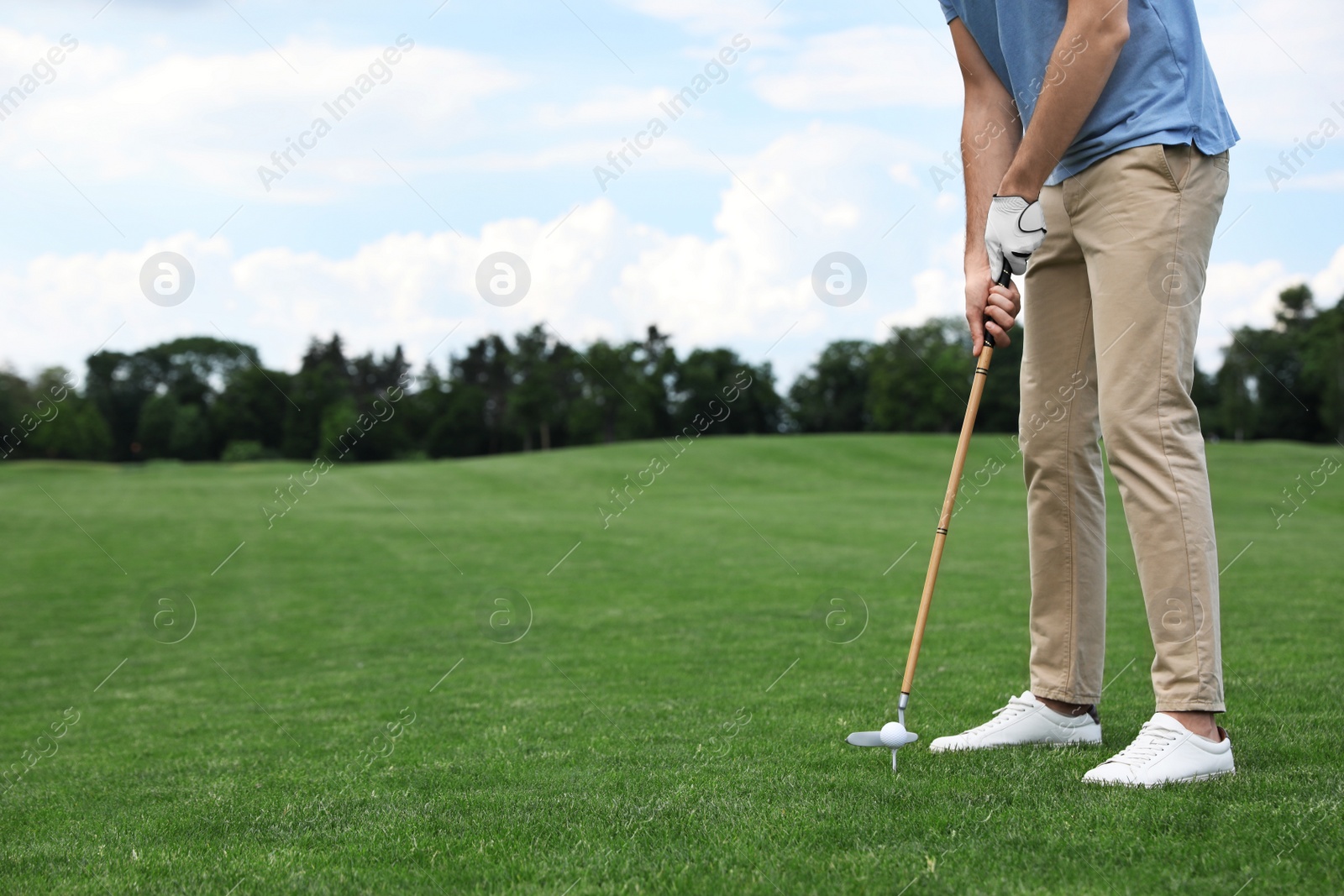 Photo of Man playing golf on green course. Sport and leisure