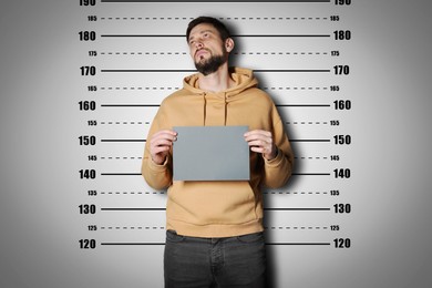 Criminal mugshot. Arrested man with blank card against height chart