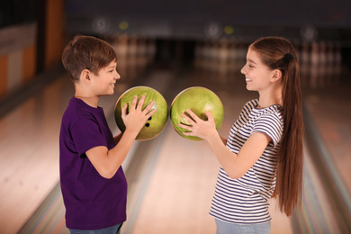 Photo of Happy children with balls in bowling club