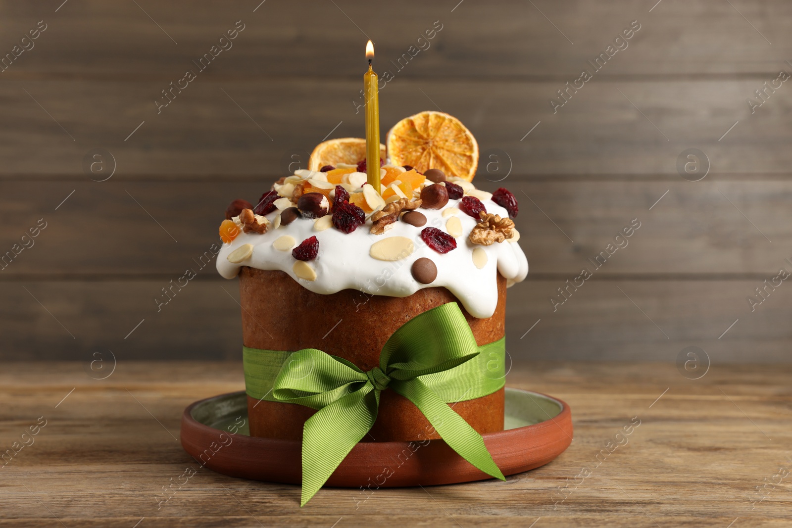 Photo of Tasty Easter cake with dried fruits and nuts on wooden table