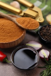 Photo of Soy sauce and different fresh ingredients for marinade on brown table, closeup