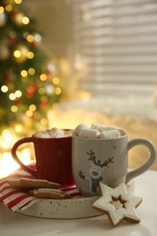 Photo of Cups of hot drink on white table indoors