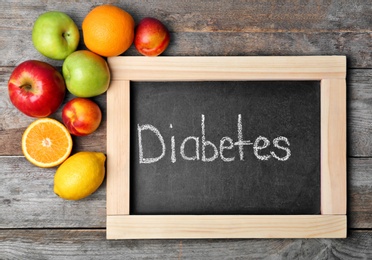 Photo of Flat lay composition with word DIABETES and fruits on wooden background