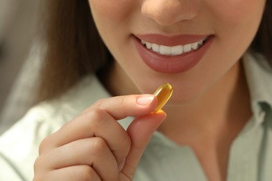Photo of Young woman taking dietary supplement pill, closeup