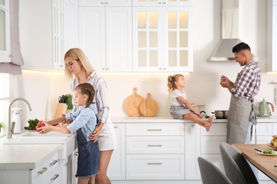 Photo of Happy family cooking together in modern kitchen