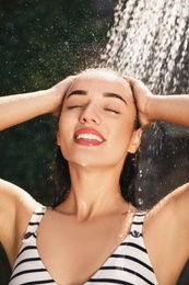 Woman washing hair in outdoor shower on summer day, closeup