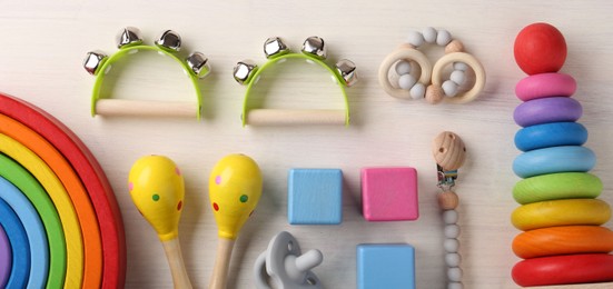Photo of Baby song concept. Flat lay composition with toy musical instruments on white wooden background