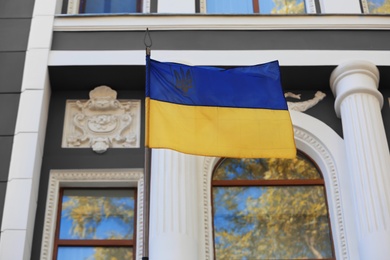 Photo of National flag of Ukraine on vintage building wall outdoors