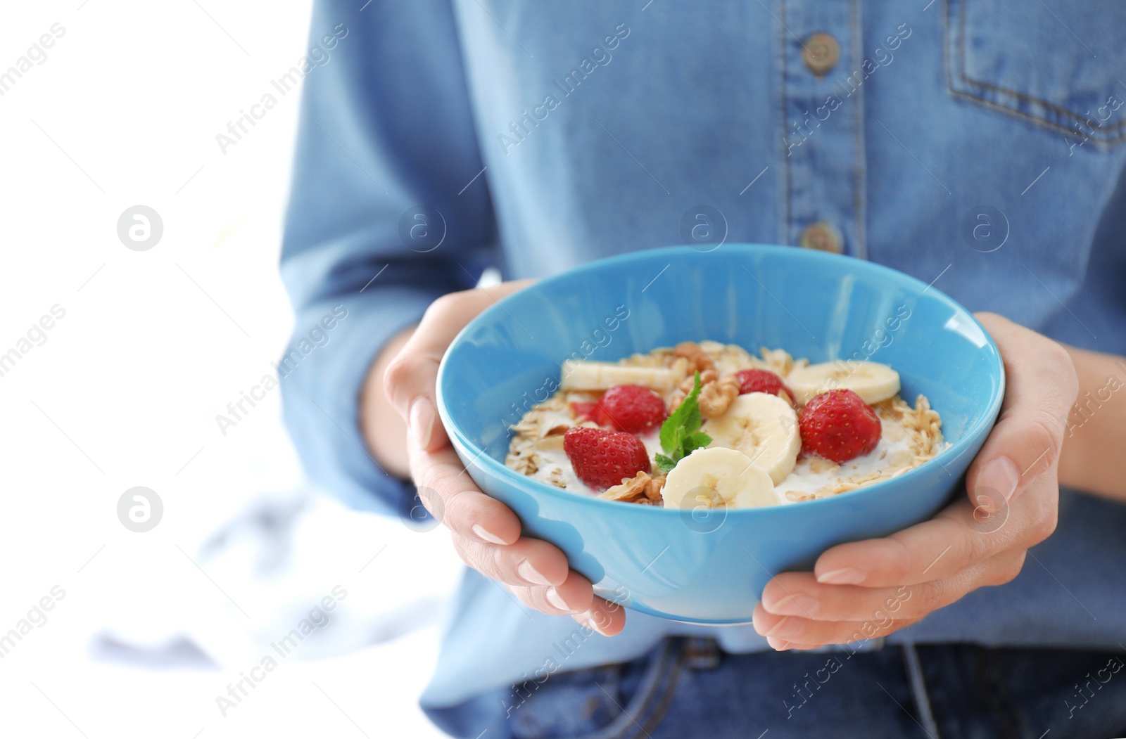 Photo of Woman holding bowl with delicious oatmeal and fruits, closeup. Healthy diet