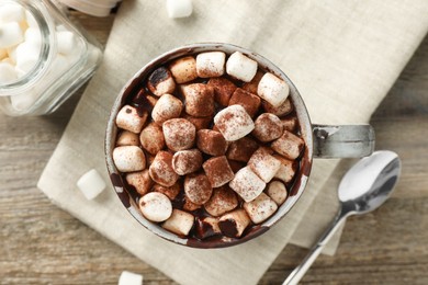 Photo of Delicious hot chocolate with marshmallows and cocoa powder in cup on wooden table, flat lay