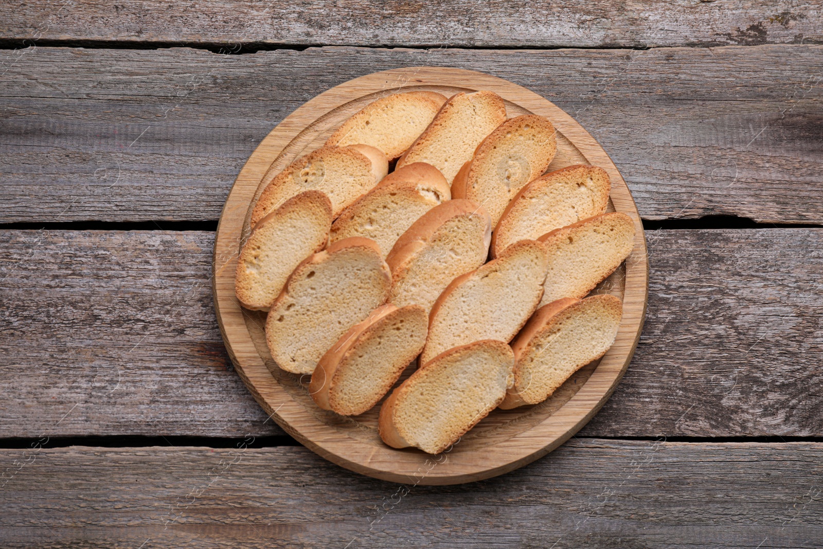 Photo of Tasty hard chuck crackers on wooden table, top view