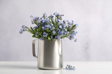 Photo of Beautiful forget-me-not flowers on white table, closeup